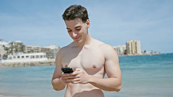 Молодой Латиноамериканец Турист Улыбается Уверенно Используя Смартфон Пляже — стоковое фото
