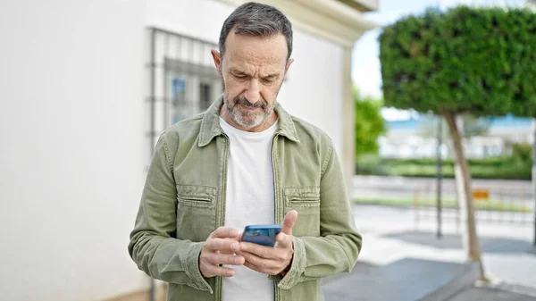 Hombre Mediana Edad Usando Teléfono Inteligente Con Expresión Seria Calle —  Fotos de Stock