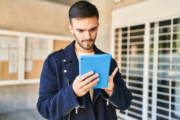 Young Hispanic Man Using Touchpad Serious Expression Street —  Fotos de Stock