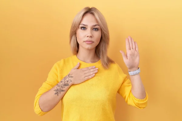 Young Caucasian Woman Wearing Yellow Sweater Swearing Hand Chest Open — Stock Photo, Image