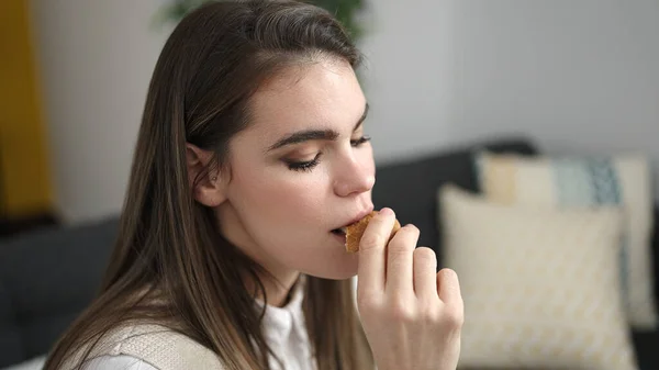 Ung Vacker Latinamerikansk Kvinna Äter Kakor Sittandes Soffan Hemma — Stockfoto