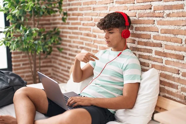 Іспанський Підліток Який Використовує Ноутбук Вдома Сидячи Спальні Вказуючи Пальцем — стокове фото