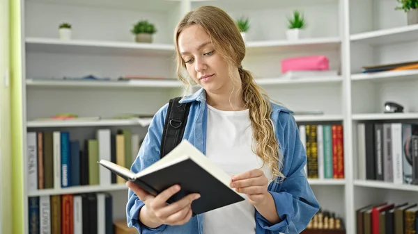 Young Blonde Woman Student Standing Reading Book Library University — Stock Photo, Image