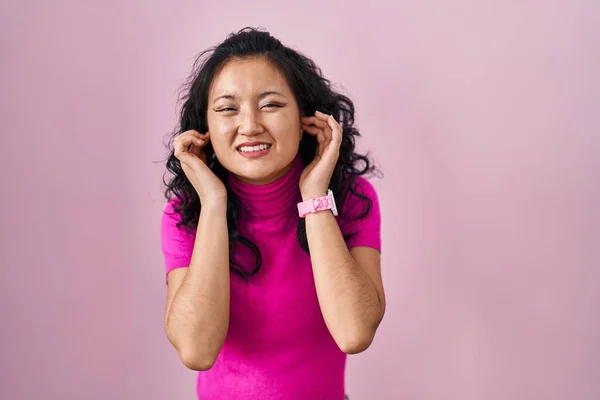 Mujer Asiática Joven Pie Sobre Fondo Rosa Cubriendo Las Orejas — Foto de Stock