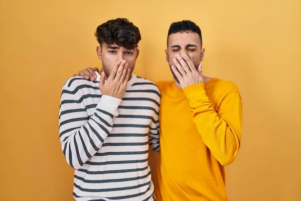 Sarı Arka Planda Dikilen Genç Spanyol Eşcinsel Çift Ağız Ağızla — Stok fotoğraf