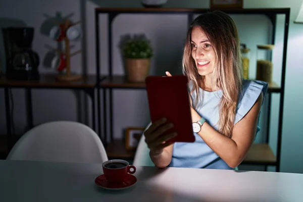 Jovem Hispânica Usando Touchpad Sentado Mesa Noite Apontando Para Lado — Fotografia de Stock