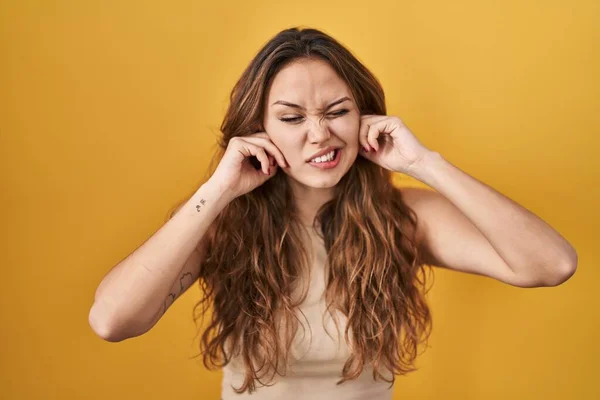 Young Hispanic Woman Standing Yellow Background Covering Ears Fingers Annoyed — Fotografia de Stock