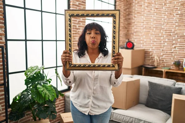 Hispanic Woman New Home Holding Empty Frame Puffing Cheeks Funny — Stock Photo, Image