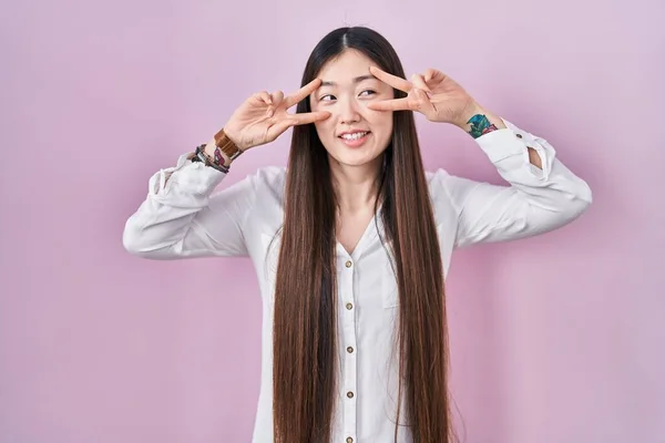Chinese Young Woman Standing Pink Background Doing Peace Symbol Fingers — Stockfoto