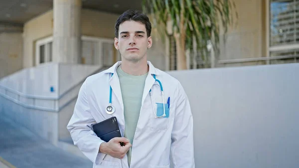 Młody Latynoski Lekarz Stojący Poważnym Wyrazem Twarzy Trzymający Touchpad Szpitalu — Zdjęcie stockowe