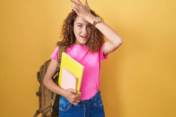 Jovem Caucasiana Usando Mochila Estudantil Segurando Livros Surpresos Com Mão — Fotografia de Stock