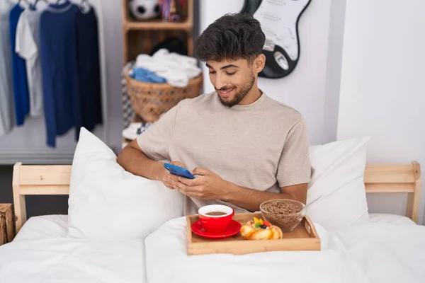 Молодой Араб Помощью Смартфона Завтракает Спальне — стоковое фото