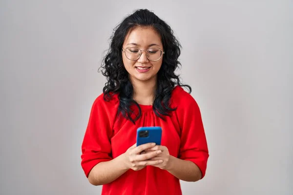 スマートフォンの入力メッセージを使用して若いアジアの女性は 顔に幸せとクールな笑顔で笑顔 歯を見せて — ストック写真