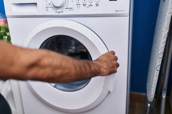 少年惊慌失措的男子在洗衣房关上洗衣机 — 图库照片