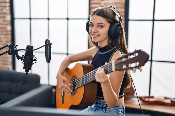 stock image Adorable girl musician singing song playing classical guitar at music studio