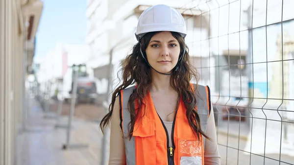 年轻美丽的惊慌失措的女建筑工人站在街上 满脸轻松的表情 — 图库照片