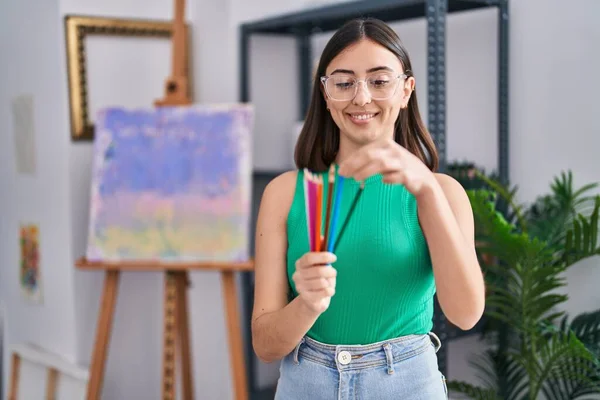 Young Hispanic Woman Holding Color Pencils Standing Art Studio — Foto de Stock