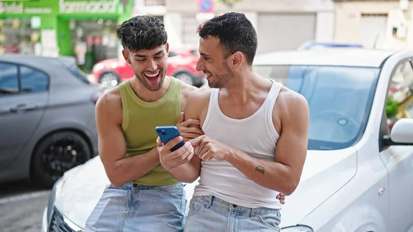二人の男が路上で車に座っているスマートフォンを使って — ストック写真