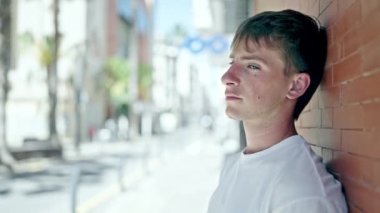Young caucasian man standing with serious expression at street