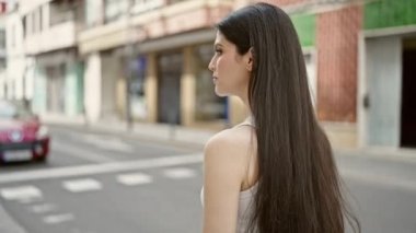 Sokakta kolları çapraz duran genç, güzel İspanyol kadın.