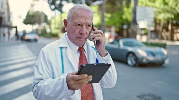 高级灰发男子医生在街上用智能手机用触摸板交谈 — 图库视频影像