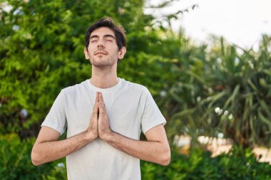 Genç İspanyol adam parkta yoga egzersizi yapıyor.