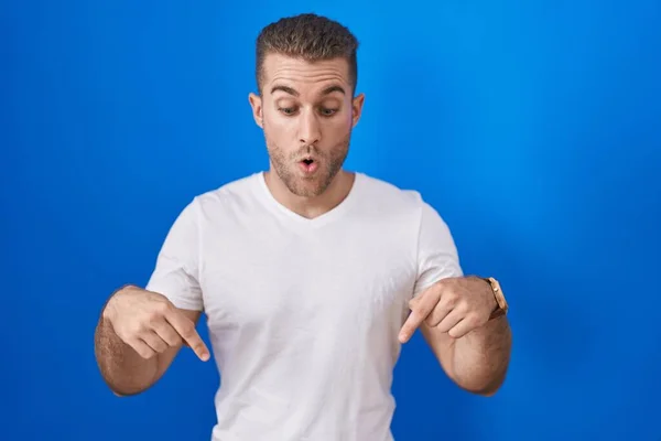 Mavi Arka Planda Dikilen Genç Beyaz Adam Parmaklarını Göstererek Reklamını — Stok fotoğraf