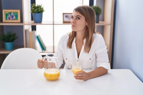Junge Hispanische Frau Trinkt Ein Glas Orangensaft Lächelt Zur Seite — Stockfoto