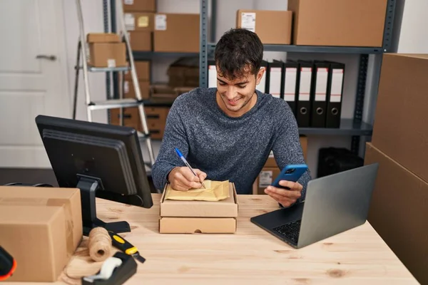 Genç İspanyol iş adamı. Ofisteki pakette akıllı telefon yazısını kullanıyor.