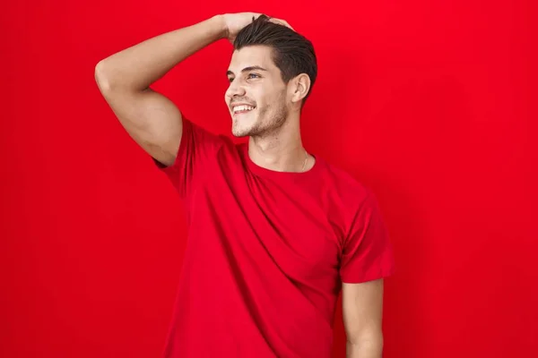 Jonge Spaanse Man Staat Rode Achtergrond Glimlachend Zelfverzekerd Aanraken Van — Stockfoto