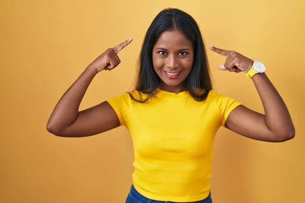 Young Indian Woman Standing Yellow Background Smiling Pointing Head Both — Stock Photo, Image