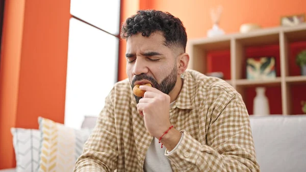 스페인 남자가 소파에 도넛을 있는데 — 스톡 사진
