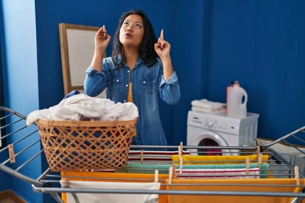 Ung Asiatisk Kvinna Hängande Kläder Vid Klädstreck Förvånad Och Förvånad — Stockfoto