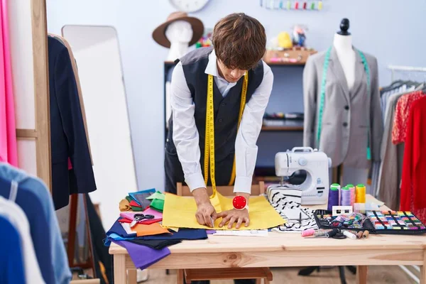 服装厂的年轻金发男子裁缝在布料上做记号 — 图库照片