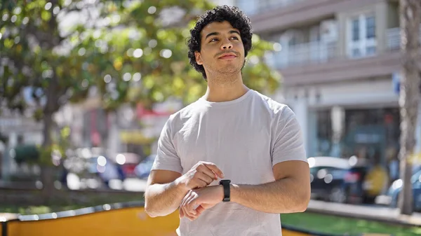 Joven Latino Sonriendo Confiado Tocando Reloj Parque — Foto de Stock