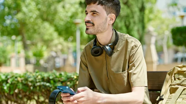 Parkta Bankta Oturan Akıllı Telefon Kullanan Genç Bir Spanyol — Stok fotoğraf