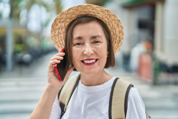中年女性観光客笑顔自信を持って話す上のスマートフォンでストリート — ストック写真