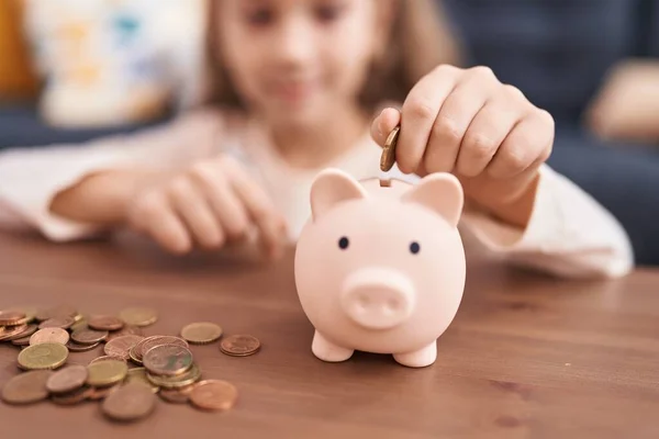 Adorable Caucasian Girl Inserting Coin Piggy Bank Sitting Sofa Home — Stock Photo, Image