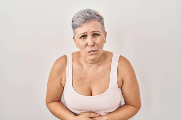 中年白种女人站在白种人的背景上 双手放在肚子上 因为恶心 痛苦的疾病感觉不适 疼痛的概念 — 图库照片