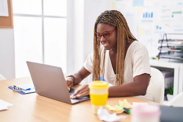 使用笔记本电脑在办公室工作的非洲裔美国女商人 — 图库照片