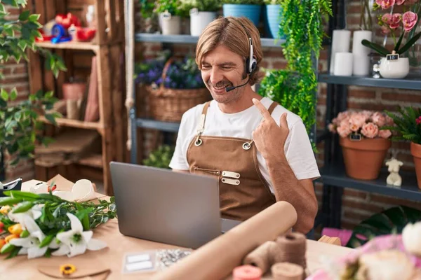Caucasian man with mustache working at florist shop doing video call smiling happy pointing with hand and finger