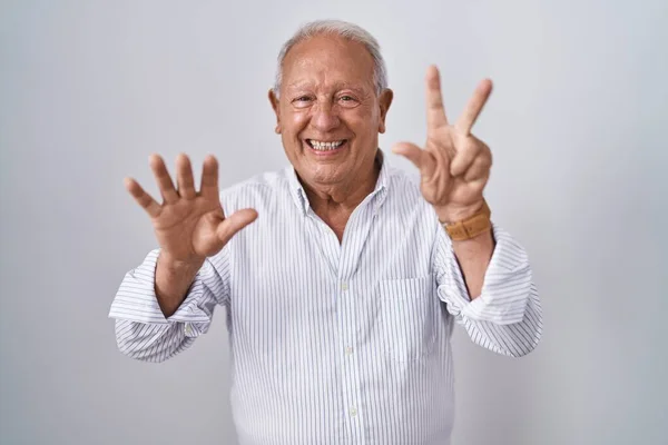一个白发苍苍的老人站在孤独的背景上 用八号手指指指着 面带微笑 自信而快乐 — 图库照片