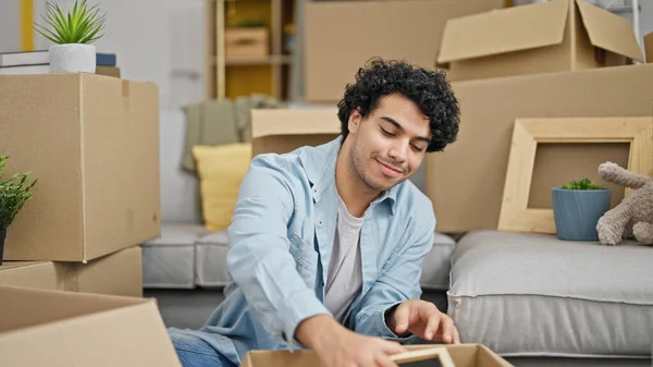 Jonge Latin Man Verpakking Kartonnen Doos Met Foto Nieuw Huis — Stockfoto