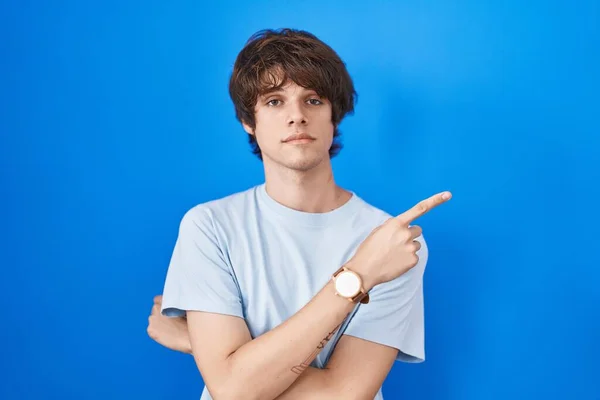 Hispanic Young Man Standing Blue Background Pointing Hand Finger Side — Stockfoto