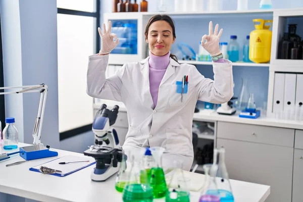 과학자 실험실에서 일하는 미녀는 손가락으로 동작을 하면서 긴장을 미소짓는다 — 스톡 사진