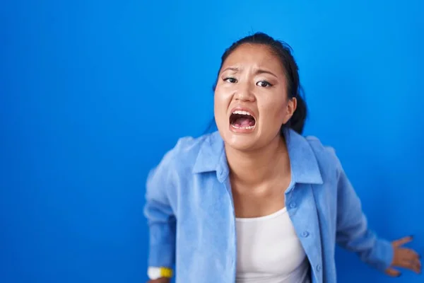 Asian Young Woman Standing Blue Background Angry Mad Screaming Frustrated — Stockfoto