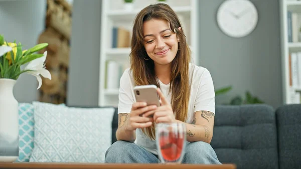 Genç Güzel Spanyol Kadın Akıllı Telefon Kullanıyor Kanepede Oturuyor Gülümsüyor — Stok fotoğraf
