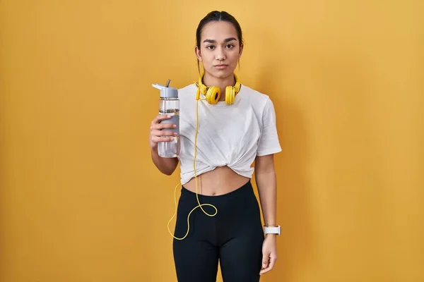 Ung Sydasiatisk Kvinna Bär Sportkläder Dricksvatten Avslappnad Med Allvarliga Ansiktsuttryck — Stockfoto