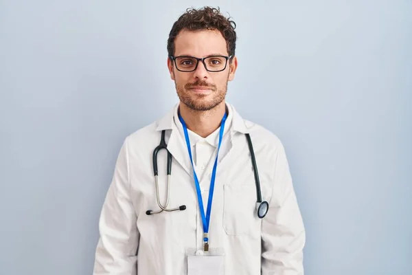 Jonge Spaanse Man Doktersuniform Stethoscoop Ontspannen Met Serieuze Gezichtsuitdrukking Eenvoudig — Stockfoto