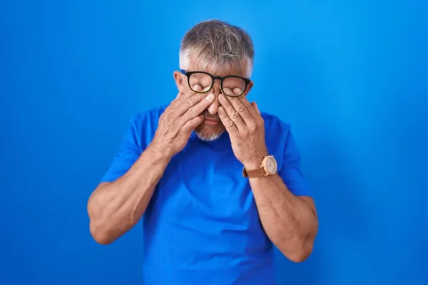 Homem Hispânico Com Cabelos Grisalhos Sobre Fundo Azul Esfregando Olhos — Fotografia de Stock